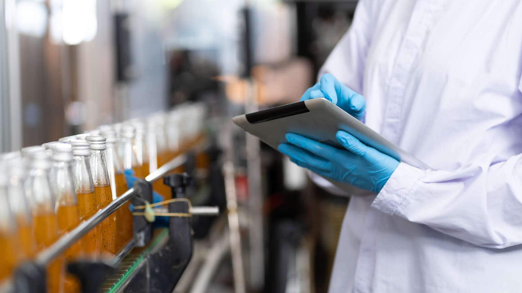 Produttore che controlla le bottiglie del prodotto