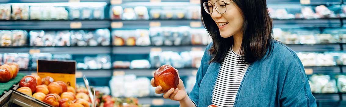 Woman picking apples in a grocery store