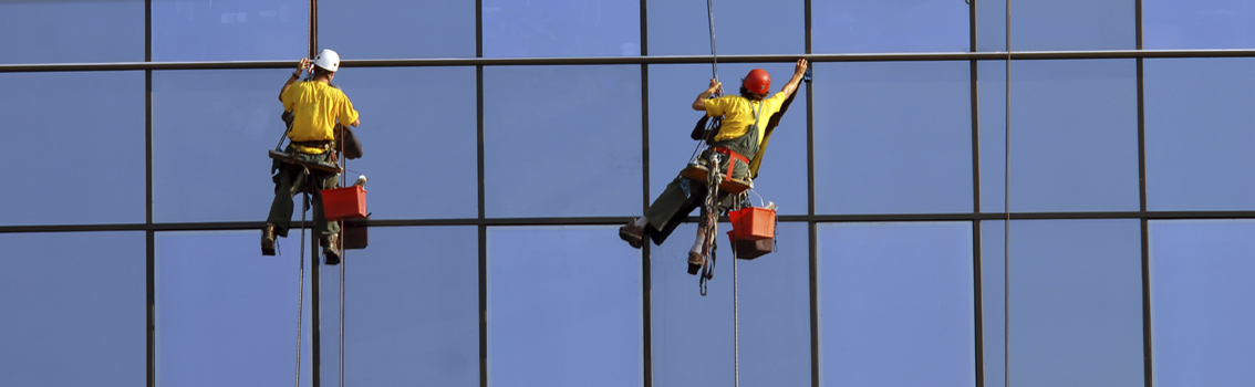 Sicurezza Lavoratori - Lavoratori che puliscono i vetri dei palazzi