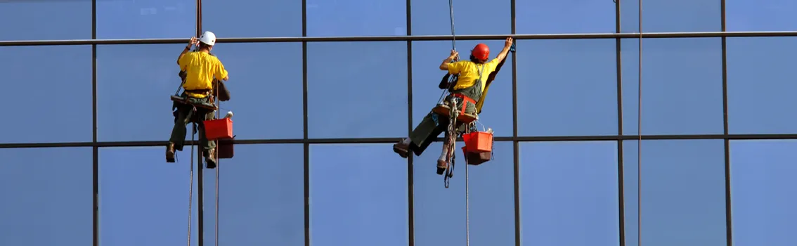 Sicurezza Lavoratori - Lavoratori che puliscono i vetri dei palazzi