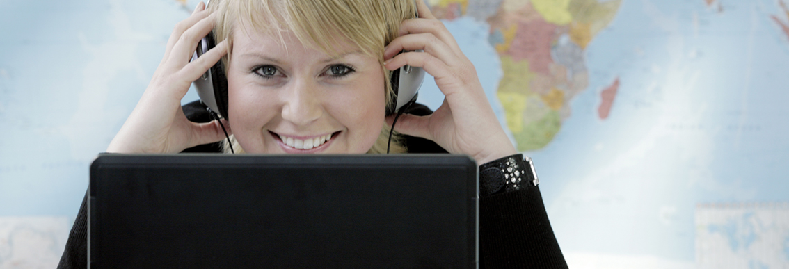 donna davanti a laptop con le cuffie