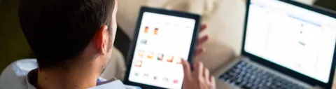 Uomo che guarda ipad e pc